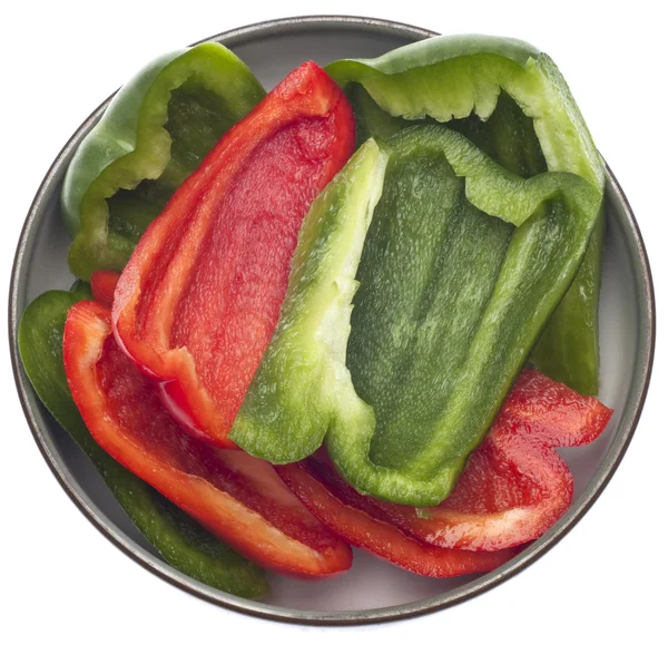 鲜切绿色和红色甜椒关闭在碗里上白色隔离 — 图库照片
