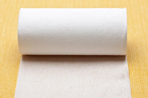 Rulle toalettpapper på gula — Stockfoto
