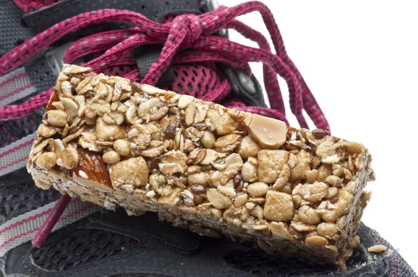 エネルギー バーとスニーカーの靴のスポーツ栄養概念をクローズ アップ — ストック写真