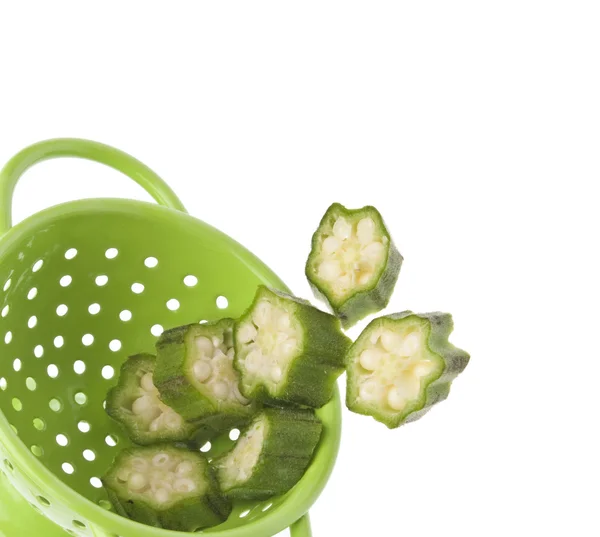 新鲜黄秋葵溢从充满活力的绿色漏勺边框 — 图库照片