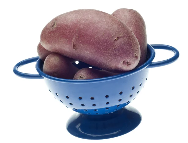 整个婴儿红马铃薯在孤立在白色与剪切路径上的蓝色漏勺 — 图库照片