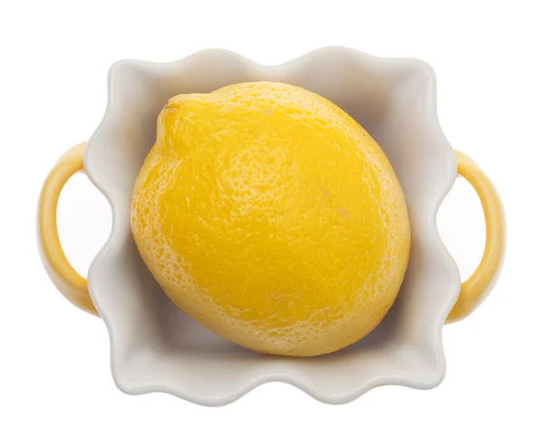 Limão em um prato de cozinha amarelo — Fotografia de Stock