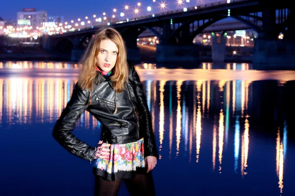 Retrato noturno da bela menina contra a ponte — Fotografia de Stock
