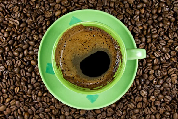 Кофе в зернах и зеленый Кубок — стоковое фото
