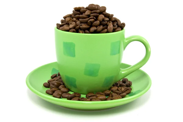 Green cup with coffee beans — Stock Photo, Image