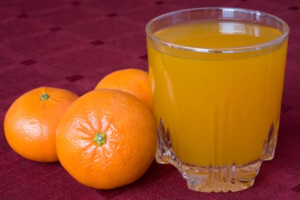 Mandarines and glass of juice — Stock Photo, Image