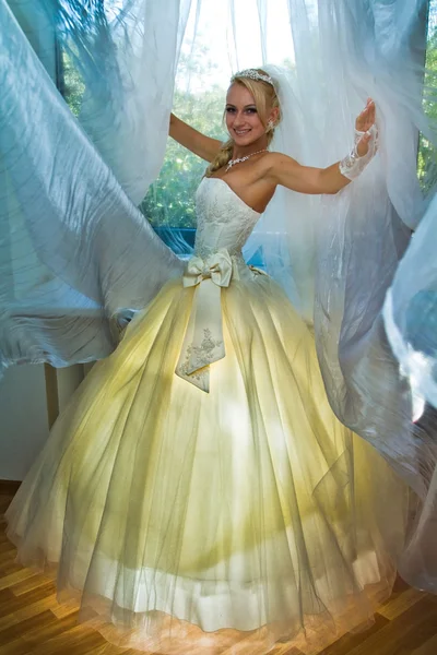 Bela jovem noiva de pé na janela — Fotografia de Stock