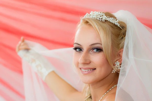 Mooie jonge bruid houden de sluier. — Stockfoto