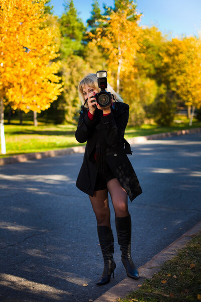 A girl holds a professional camera.