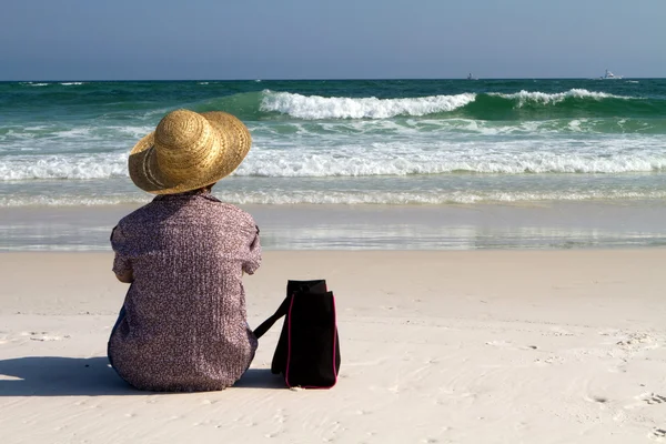 バッグとビーチに座っている女性 — ストック写真