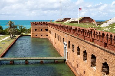 Wooden footpath crosses the moat and leads to the entrance of Fort Jefferson National Park in the Dry Tortugas. clipart