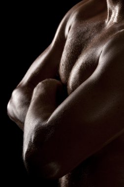 Athletic male torso in dark key. Focus on the chest. clipart