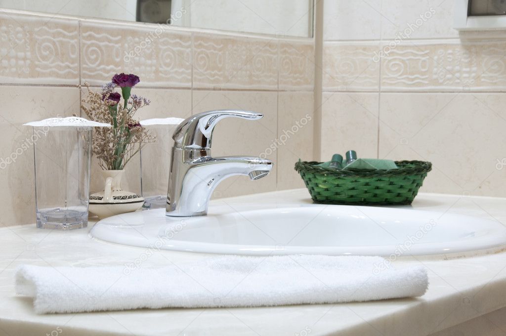 Hotel bathroom: sink, tap, towel and bathroom set