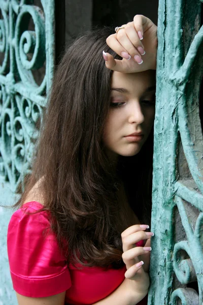 Young caucasian woman near the gates — Stock Photo, Image
