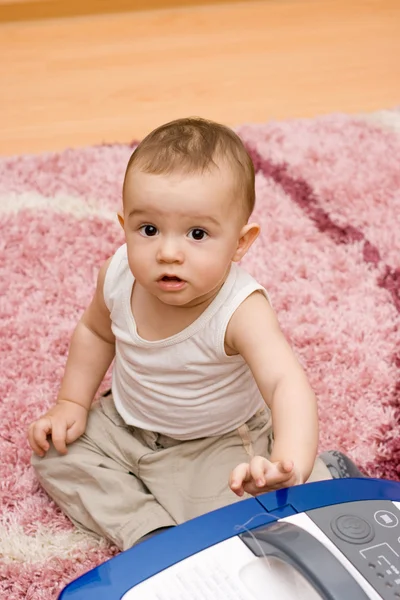 Cute caucasian baby with vacuum cleaner — Stock Photo, Image