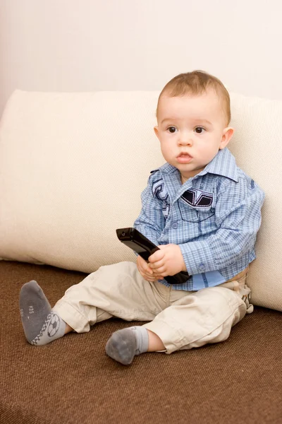 Schattige Kaukasische jongen met tv-console — Stockfoto