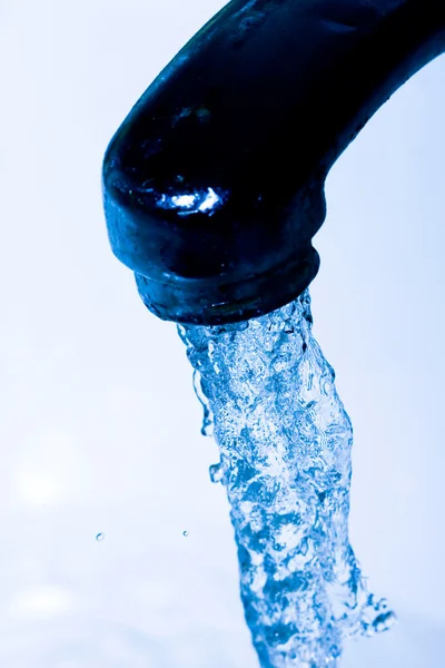 Water running down from faucet in blue color — Stock Photo, Image