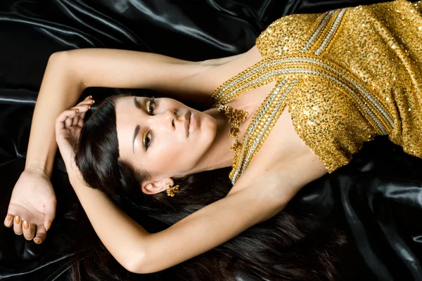 Красивая модная женщина в золотом платье — стоковое фото