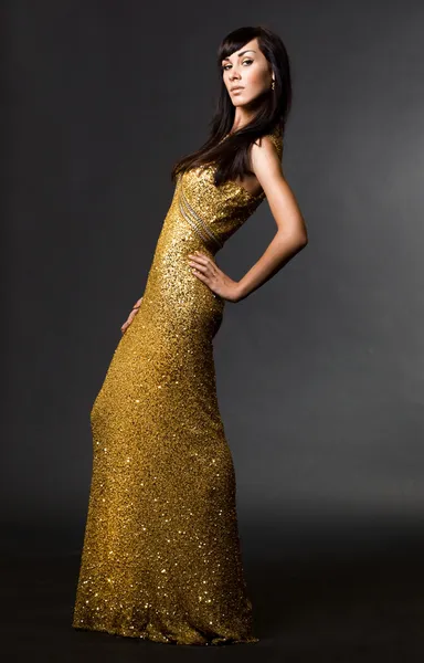 Schöne modische Frau im goldenen Kleid — Stockfoto