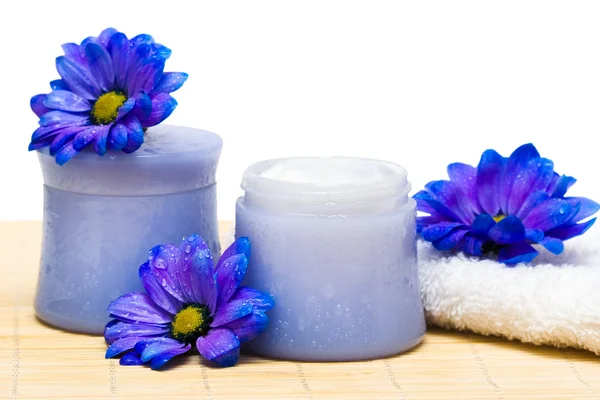 Essenciais spa, creme e toalha com flores azuis — Fotografia de Stock