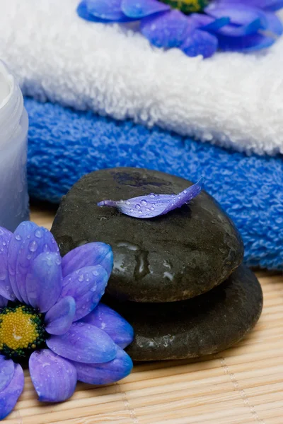 Krém, kameny a ručník s květinami — Stock fotografie