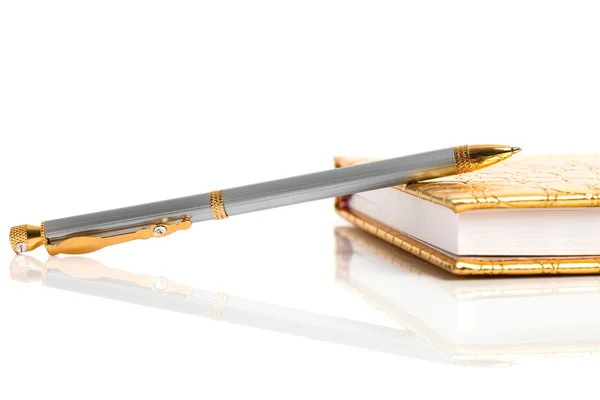 Золотой блокнот с серебряной ручкой — стоковое фото