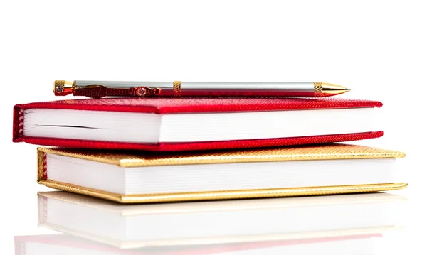 Golden and red notebooks with silver pen — Stock Photo, Image