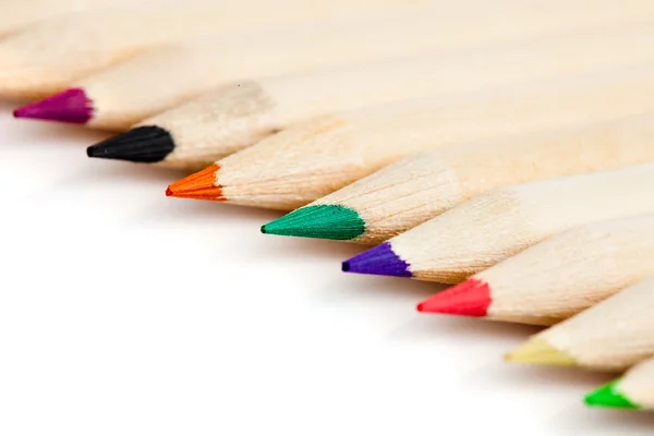 Muitos lápis coloridos em linha sobre fundo branco — Fotografia de Stock