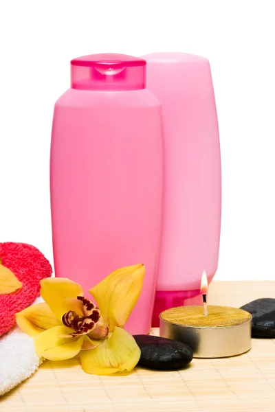 Bougie, bouteille de shampooing avec pierre et orchidée — Photo