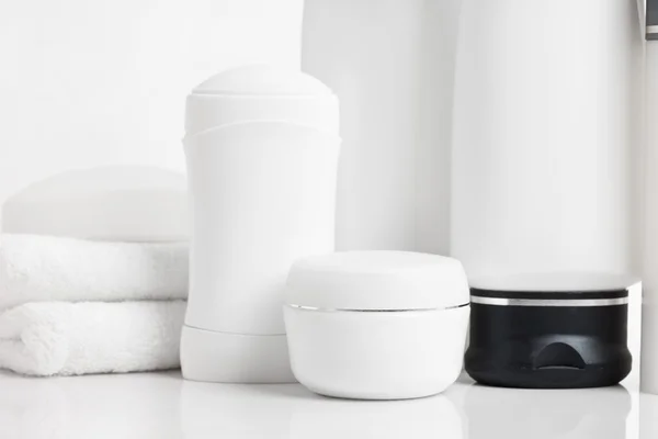 Bottiglie con crema e shampoo su sfondo bianco — Foto Stock