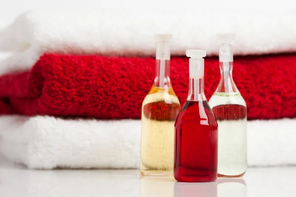 Pila di asciugamani rossi e bianchi con bottiglie — Foto Stock