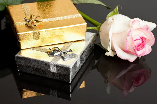 Geschenkboxen mit Rose auf schwarzem Hintergrund — Stockfoto