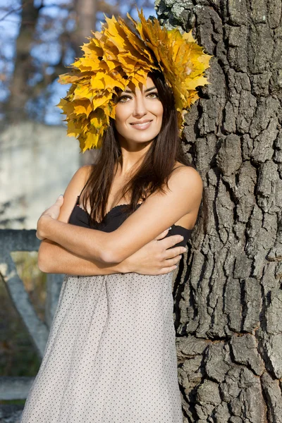 Женщина с желтыми листьями осенью — стоковое фото