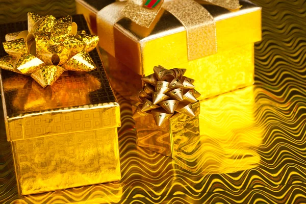 Slavnostní dárkové boxy na zlatém pozadí — Stock fotografie