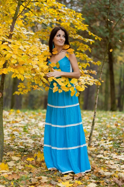 Mujer con hojas amarillas en otoño — Foto de Stock