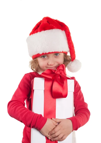 Uma menina pequena com um chapéu de Natal e um presente — Fotografia de Stock
