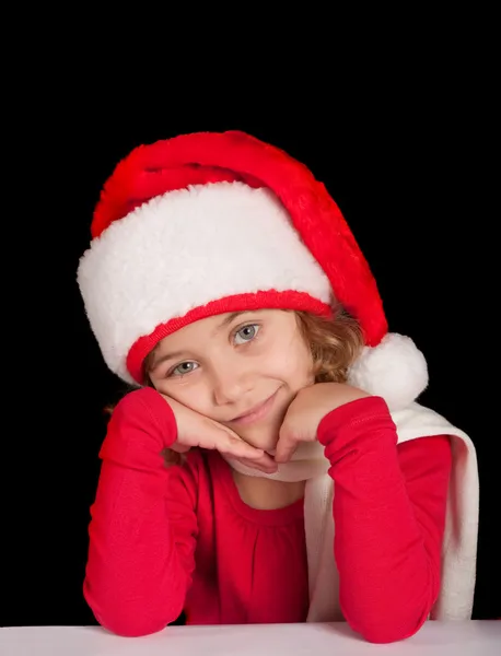 Милая девушка в рождественской шляпе, мечтающая — стоковое фото