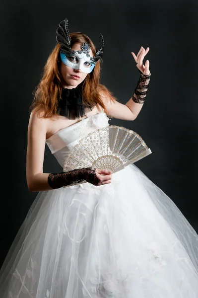 Flicka med fläkt och mask i vit klänning — Stockfoto