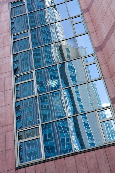 Moln i glasade panel skyskrapa — Stockfoto