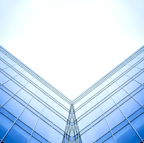 Symmetriska vägg av glas byggnad i diset — Stockfoto
