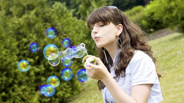Chica joven soplando burbujas de jabón en el parque de otoño —  Fotos de Stock