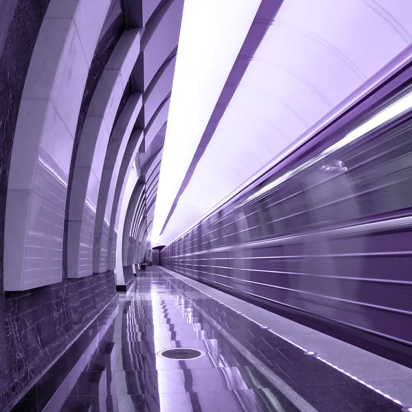 Абстрактная фиолетовая станция с движущимся поездом — стоковое фото