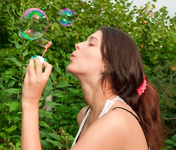 Giovane ragazza che soffia bolle di sapone nel parco autunnale — Foto Stock