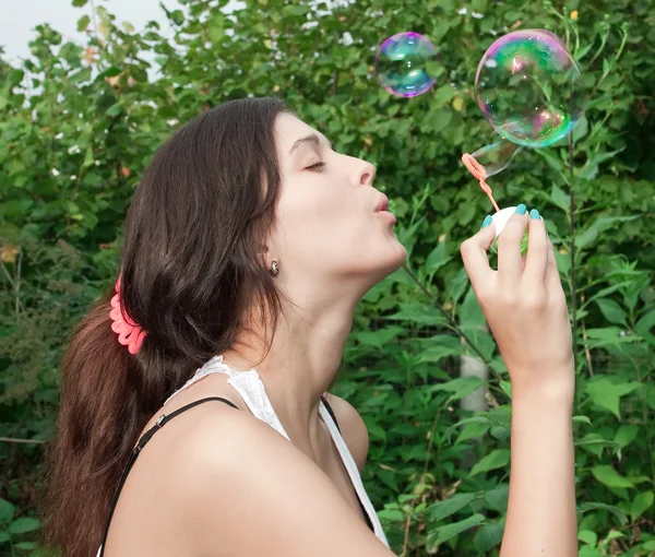 Ung flicka blåser såpbubblor i höst park — Stockfoto