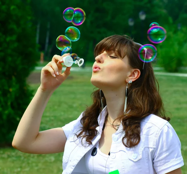 Jong meisje blazen van zeepbellen in herfst park — Stockfoto
