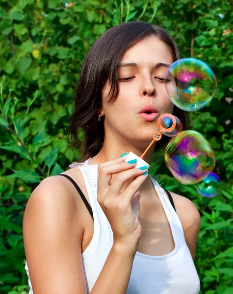 Giovane ragazza che soffia bolle di sapone nel parco autunnale — Foto Stock