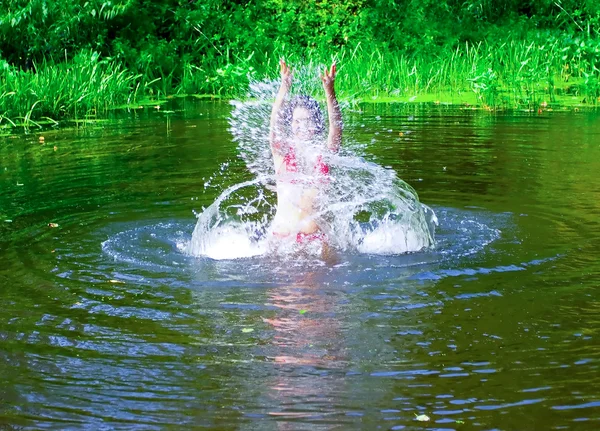 Sexy brunette meisje springen met spatten in de rivier — Stockfoto