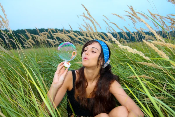 年轻的姑娘在秋天公园吹肥皂泡泡 — 图库照片