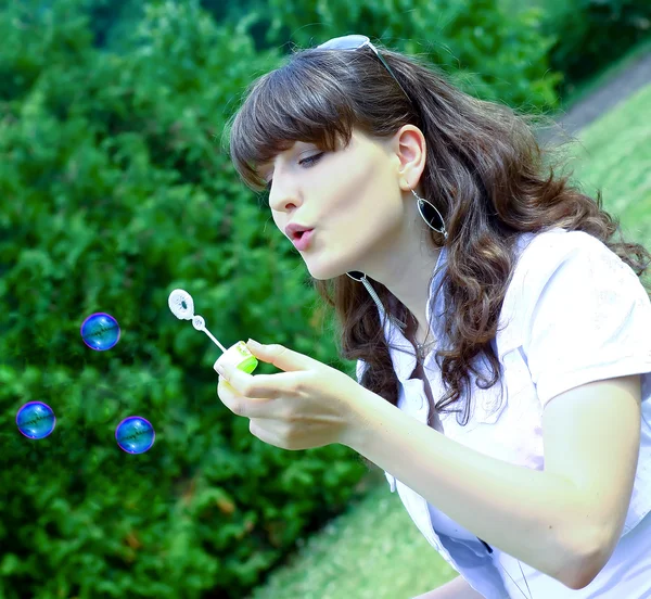 Chica joven soplando burbujas de jabón en el parque de otoño —  Fotos de Stock