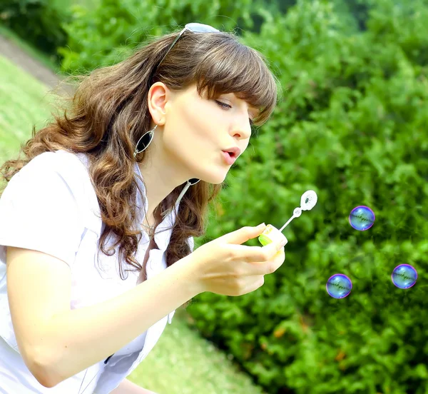 年轻的姑娘在秋天公园吹肥皂泡泡 — 图库照片
